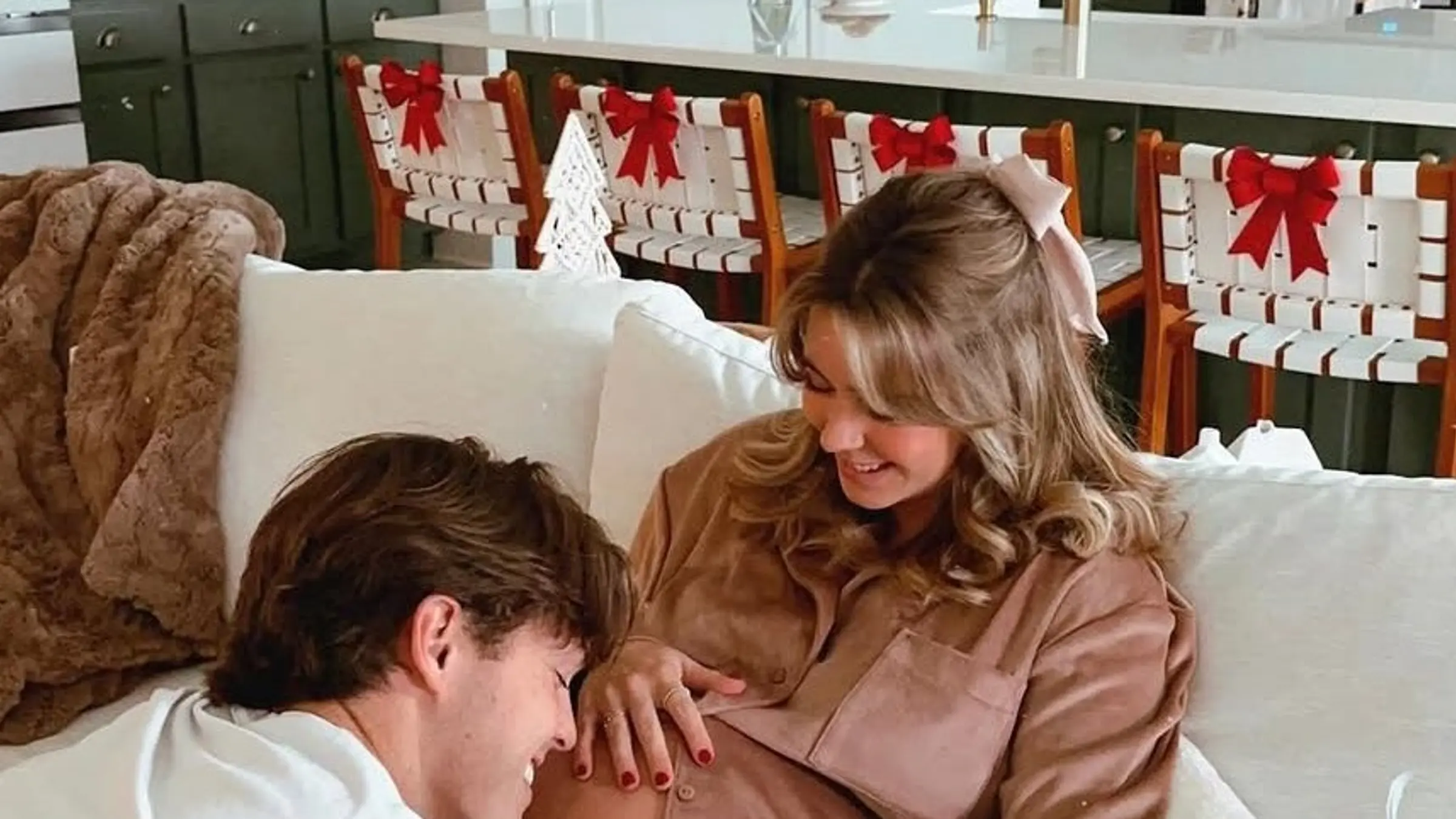 A quiet close-up lifestyle scene with two people leaning near each other in soft natural light, suggesting tenderness and emotional safety