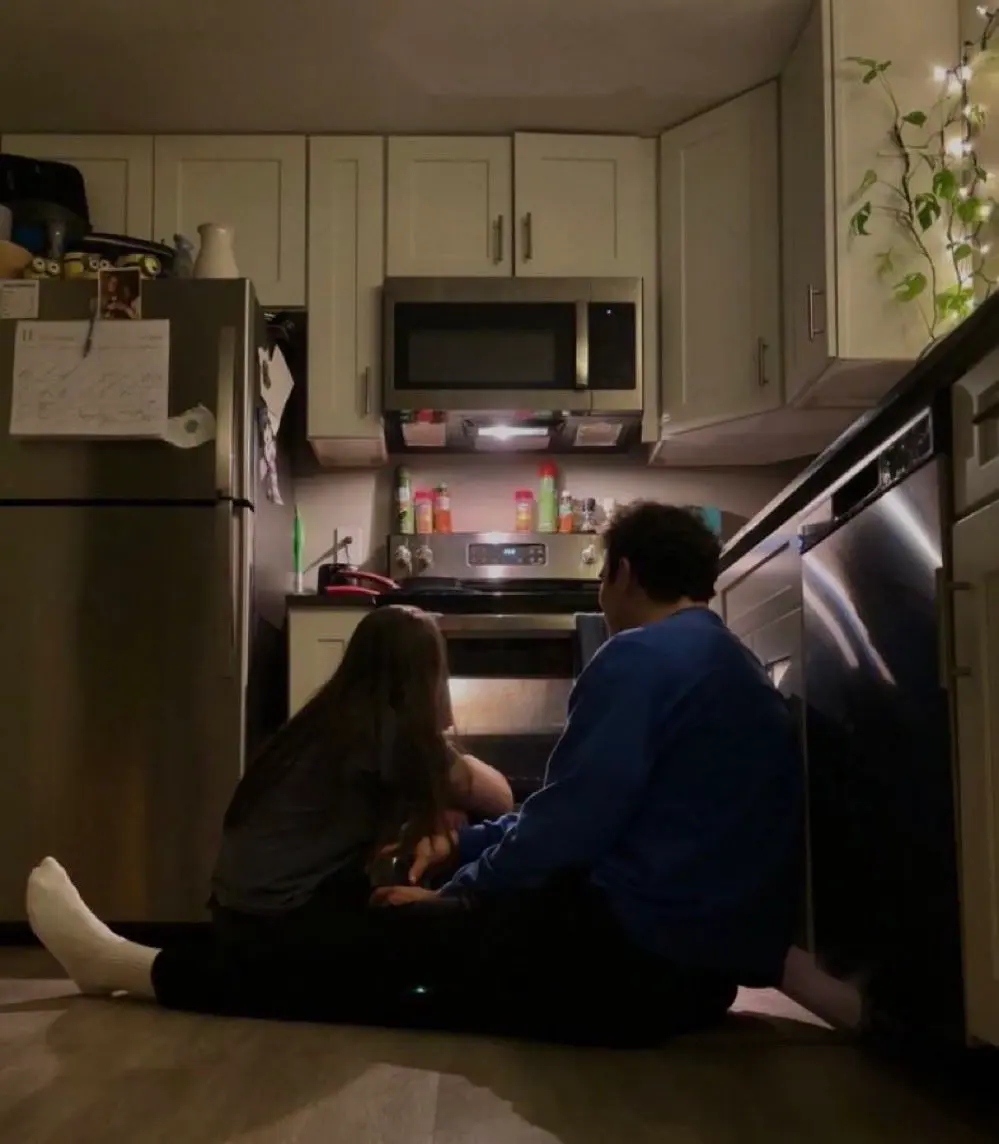 A couple sitting quietly on a kitchen floor during a serious relationship moment