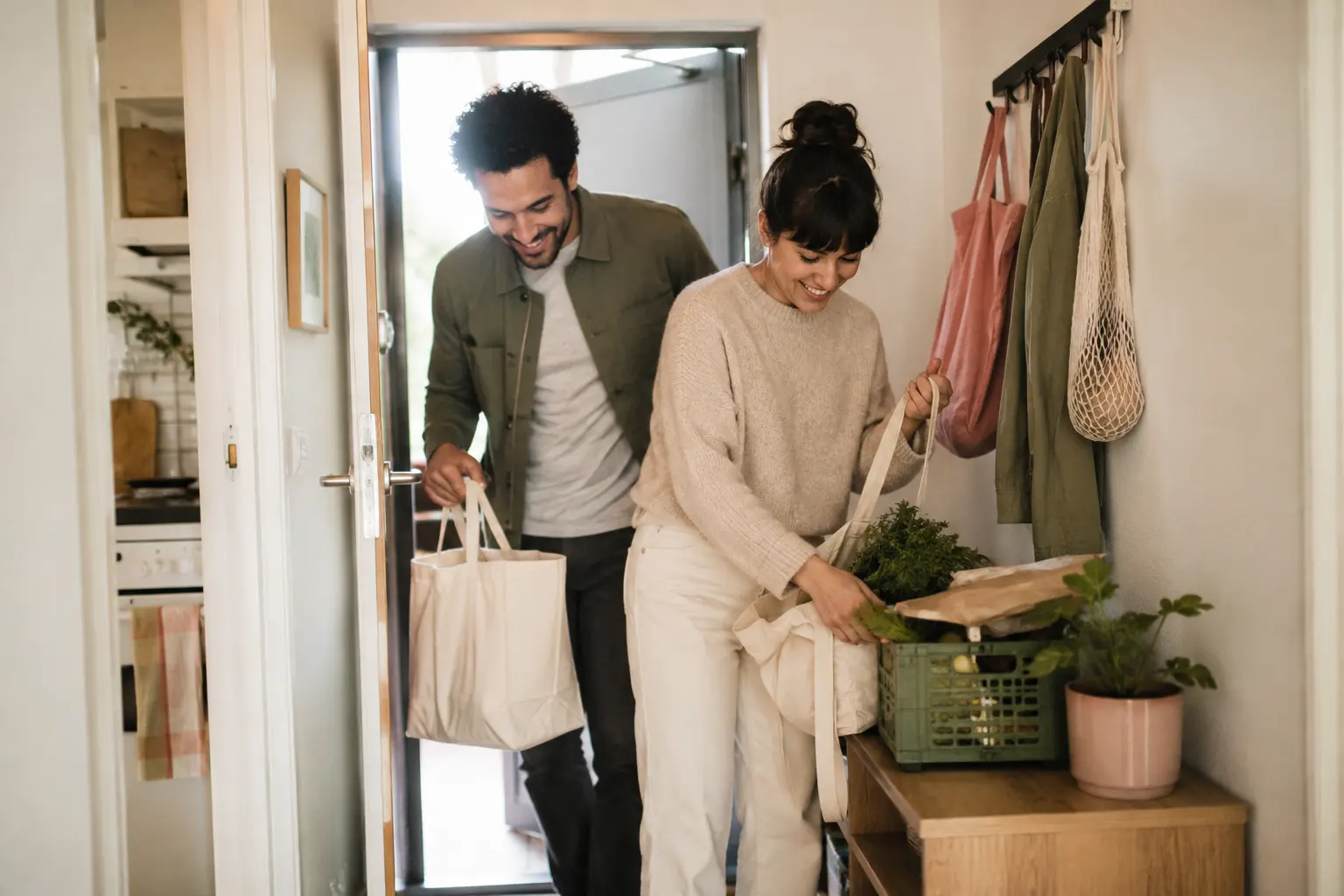 Two partners bringing groceries inside and sharing an ordinary household task